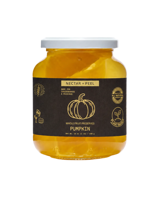 Jar of pumpkin preserve with a black label on a white background